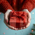 Festive touch Womans hands present a red gift with ribbon