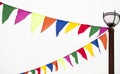 Festive triangular flags in the form of garlands hang tied to a lamppost. Decoration ideas in celebration of an event Royalty Free Stock Photo