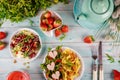 Festive Valentines Day dinner with colorful pasta, arugula salad and strawberry on white wooden background