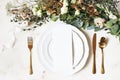 Festive wedding, birthday table setting with golden cutlery, silk ribbon, eucalyptus branches, hydrangea and white roses