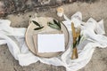Festive wedding summer table setting. Golden cutlery, olive branch, glass of wine and envelope on porcelain dinner plate
