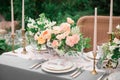 A festive wedding table with candles, glasses, decorated with flowers. The decor is made in orange and green tones. Close up. On Royalty Free Stock Photo