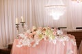 festive wedding table decoration with crystal chandeliers, golden candlesticks, candles and white pink flowers . stylish Royalty Free Stock Photo