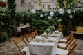 Festive wedding table setting with flowers at small reception in backyard in summer. Royalty Free Stock Photo