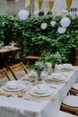 Festive wedding table setting with flowers at small reception in backyard in summer. Royalty Free Stock Photo