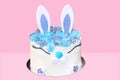 Festive white Easter cake in the shape of a hare for decoration and decoration on an isolated pink background. Royalty Free Stock Photo