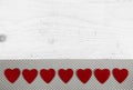 Festive white shabby chic background with red hearts on wood.