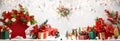 Festive winter flower arrangement in vase of red star shape and gift boxes on table. Christmas or New Year concept Royalty Free Stock Photo