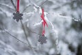 Beautiful Christmas background of unique black ceramic decoration shape of snowflakes with red ribbon on tree branches