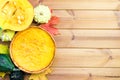 Festive wooden table with pumpkin pie, decorative pumpkins and maple leaves