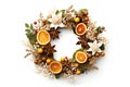 A festive wreath with dried orange slices star anise nuts and botanical elements beautifully arranged on a white background