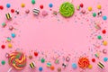 wreath background with assortment of colourful caramel candies with jelly and sprinkles over pink and space for your Royalty Free Stock Photo