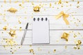 Festivedecorations and notebook with wish list on white rustic table, flat lay style. Planning concept.- Image Royalty Free Stock Photo
