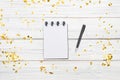 Festivedecorations and notebook with wish list on white rustic table, flat lay style. Planning concept.- Image Royalty Free Stock Photo
