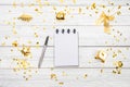 Festivedecorations and notebook with wish list on white rustic table, flat lay style. Planning concept.- Image Royalty Free Stock Photo