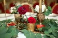Festively decorated banquet table in the restaurant. Fresh flowers are golden candles and red chairs and garnet. expensively rich Royalty Free Stock Photo