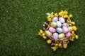 Festively decorated Easter eggs on green grass, top view. Space for text