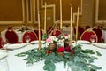 Festively decorated round banquet table in the restaurant. Fresh flowers are golden candles and red chairs. expensively rich Royalty Free Stock Photo