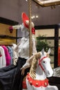 Festively decorated shop window of a women& x27;s store. A mannequin in a red hat sits on a toy Christmas horse Royalty Free Stock Photo