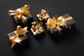 Festively wrapped golden gift boxes on black background. Isometric view. Holiday and black friday concept