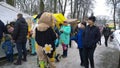 Festivities and trade fair in the city park. Crowd of people walking. Shopping tents on the street. Cold weather, sleet. Real life Royalty Free Stock Photo