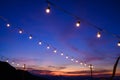 Festoon string lights decoration at the party event festival against sunset sky. light bulbs on string wire with copy space. Royalty Free Stock Photo