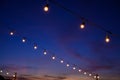 Festoon string lights decoration at the party event festival against sunset sky. light bulbs on string wire with copy space. Royalty Free Stock Photo