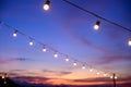 Festoon string lights decoration at the party event festival against sunset sky. light bulbs on string wire with copy space. Royalty Free Stock Photo