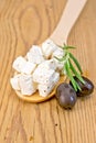 Feta in wooden spoon with olives on board Royalty Free Stock Photo