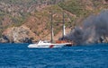 Fire on Turkish yacht in the Mediterranean Sea. Coast guard boat came to the rescue. The yacht is all on fire. Oludeniz,Fethiye,Mu