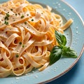 Fettuccine Alfredo pasta with cream sauce, traditional italian meal served on pastel blue plate