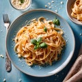 Fettuccine Alfredo pasta with cream sauce, traditional italian meal served on pastel blue plate