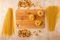 Fettuccine on a bamboo cutting Board and different macaroni on a wooden background