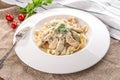 Fettuccine pasta with chicken and cheese sauce on white plate on tablecloth Royalty Free Stock Photo