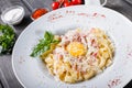 Fettuccine pasta with meat, ham, egg, parmesan cheese, basil and cream sauce on plate on dark wooden background Royalty Free Stock Photo