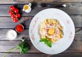 Fettuccine pasta with meat, ham, egg, parmesan cheese, basil and cream sauce on plate on dark wooden background Royalty Free Stock Photo