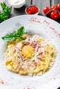 Fettuccine pasta with meat, ham, egg, parmesan cheese, basil and cream sauce on plate Royalty Free Stock Photo