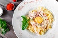 Fettuccine pasta with meat, ham, egg, parmesan cheese, basil and cream sauce on plate Royalty Free Stock Photo