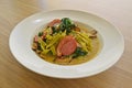 Fettuccine pasta in tasty broth fresh green spinach and slices of smoked duck