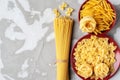 Fettuccine paste on a softly blurred background of red ceramic dishes and other paste