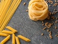 Fettuccine, spaghetti, penne, fusilli from durum wheat and wheat grains, on a dark textured background. Element for design