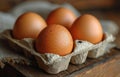 A few brown hard boiled eggs in a box. A collection of fresh eggs neatly arranged in a carton placed on a wooden table Royalty Free Stock Photo