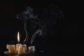 A few Candles isolated over dark background. Used, almost extinguished. Burned out. Copy space. Mystical smoke swirls in the Royalty Free Stock Photo