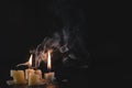 A few Candles isolated over dark background. Used, almost extinguished. Burned out. Copy space. Mystical smoke swirls in the Royalty Free Stock Photo