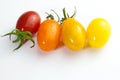 Few cherry tomatoes in a row for color nuance on white background