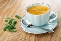 Few marmalade in form green bean, coffee in cup, spoon on saucer on wooden table Royalty Free Stock Photo