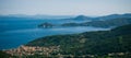 Few cliffs covered by green vegetation with Marciana Marina on Elba island Royalty Free Stock Photo