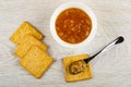 Few cookies, bowl with lemon jam, spoon with jam on cracker on wooden table. Top view Royalty Free Stock Photo