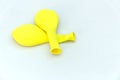 A few deflated yellow balloons on white background