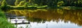 A few fishing bridges or platforms on the forrest lake where trees reflects in water, panoramic background Royalty Free Stock Photo